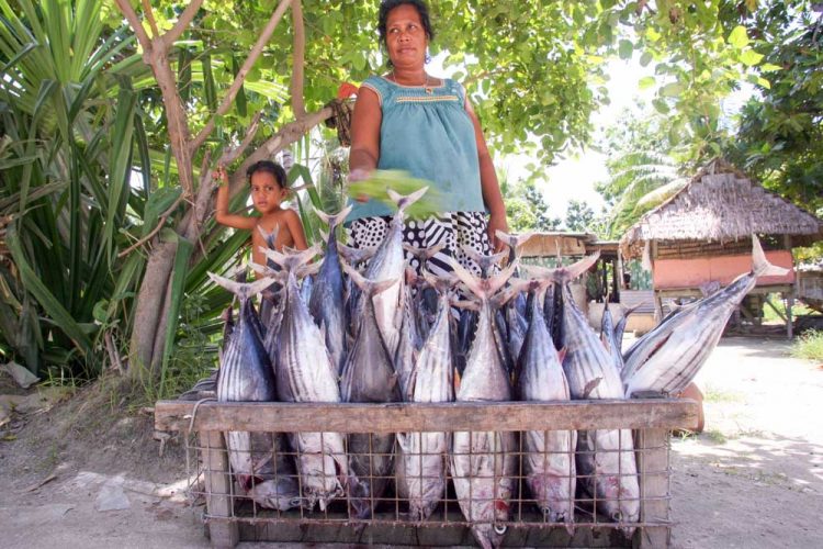Woman standing behind crate of tuna for sale. Photo: Pacific Community.