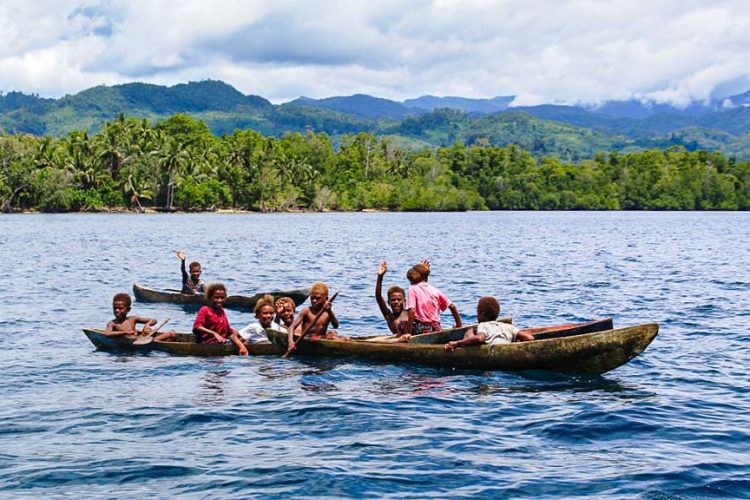 Children in wooden dug-out canoes enjoying paddling near shore in Bina Harbour, Solomon Islands. Photo: Wilson B. Saeni.